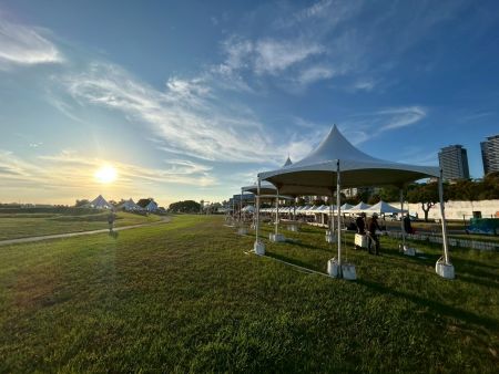 Hexagonal Tents Along the Riverside Lawn